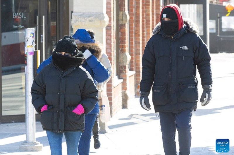 People brave the cold as they walk on a street in Toronto, Canada, on Feb. 3, 2023. Environment Canada has issued an extreme cold warning for Toronto on Friday. (Photo by Zou Zheng/Xinhua)