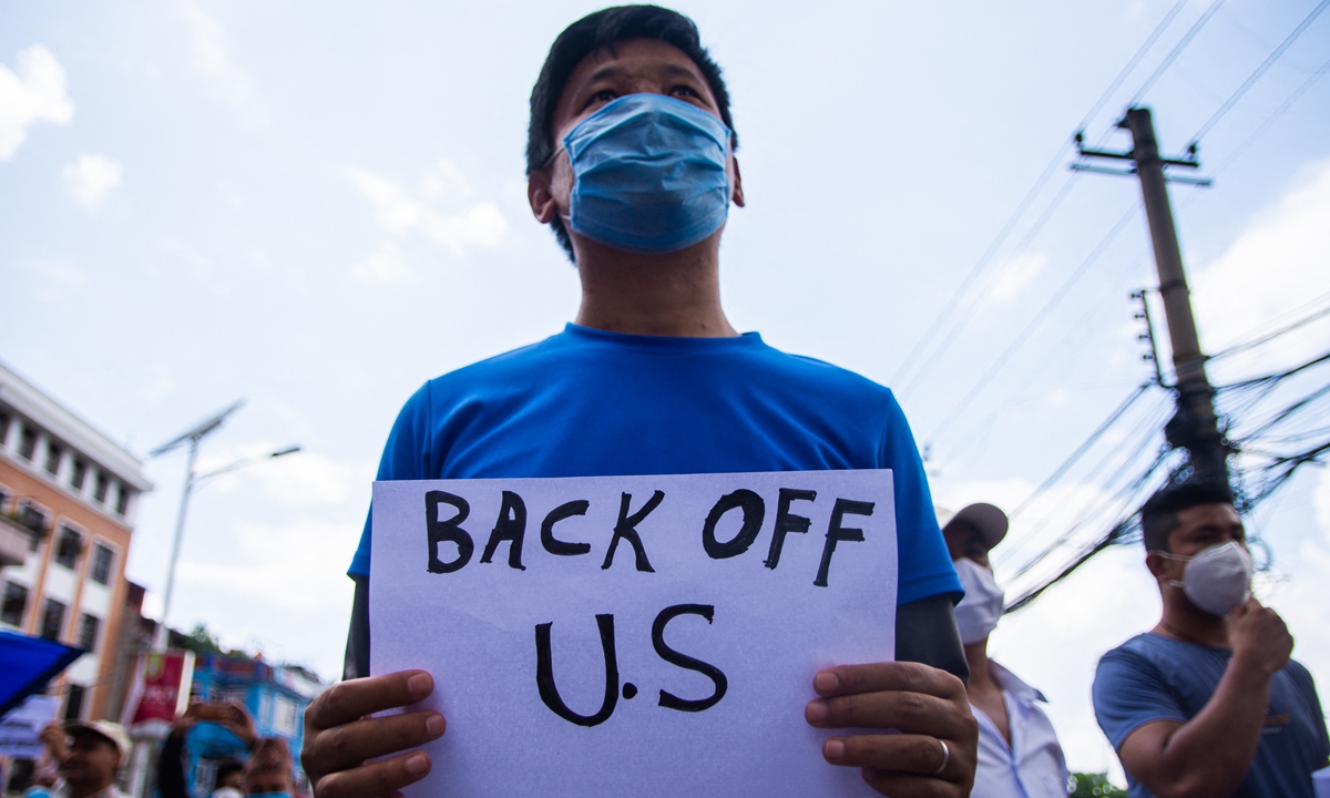 A Nepali man holds a playcard in a protest against the Millennium Challenge Corporation (MCC) agreement between Nepal and the US in Kathmandu, Nepal on June 27, 2020. Photo: AFP