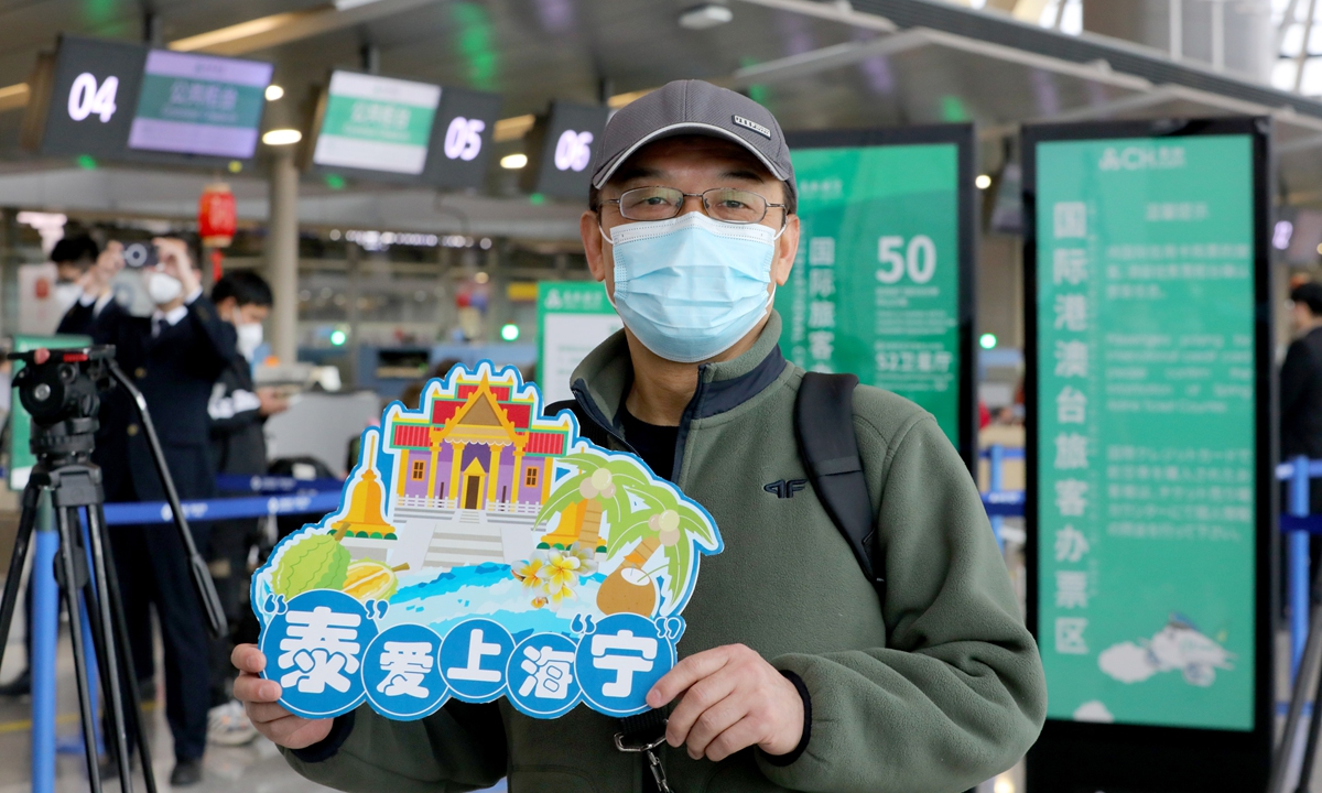 A tourist holds a sign that reads Thailand loves Shanghai people at a Shanghai airport on February 6, 2023. A tour group departed from the airport and flew to Thailand's Phuket, one of the first Chinese tour groups to head abroad following China's resumption of outbound group tours. Photo: Chen Xia/GT