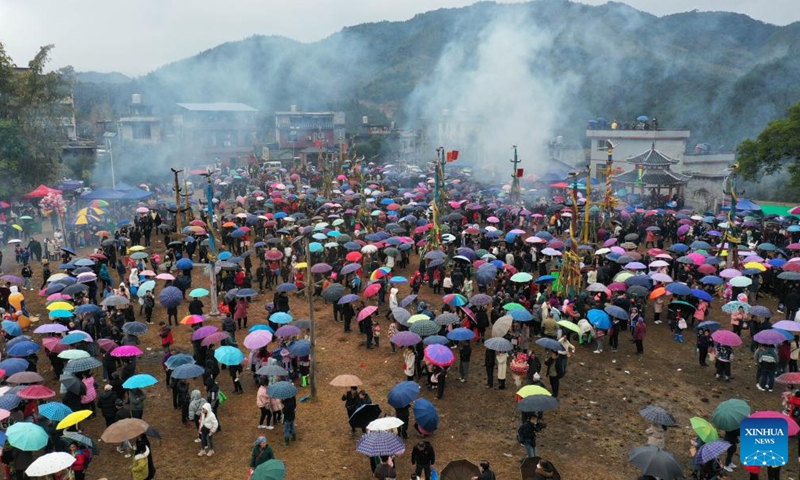 This aerial photo taken on Feb. 6, 2023 shows local people and tourists watching performance during the pohui festival in Xiangfen Town of Rongshui Miao Autonomous County, south China's Guangxi Zhuang Autonomous Region. Since the Spring Festival, villages in Rongshui Miao Autonomous County have held various activities to celebrate the pohui festival, a traditional festival observed by the Miao ethnic minority, and to boost local tourism.(Photo: Xinhua)