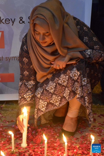 A woman lights candles during a candle light vigil for the victims of earthquakes in Türkiye and Syria, in Islamabad, capital of Pakistan on Feb. 6, 2023.(Photo: Xinhua)