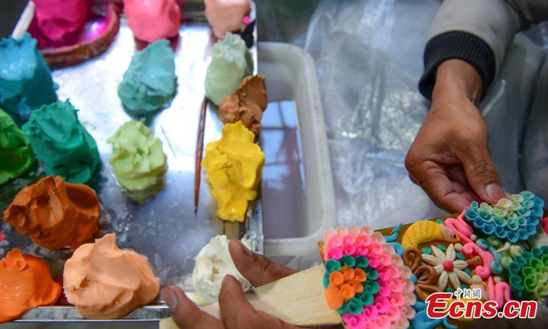 A craftsman makes butter sculptures to greet the upcoming Losar, or Tibetan New Year in Lhasa, southwest China's Tibet Autonomous Region, Feb. 7, 2023. (Photo/China News Service)
