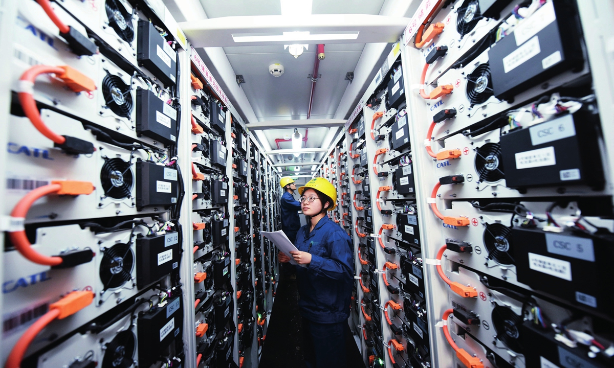 Two workers from a power supply company check the operation of the energy storage equipment produced by CATL. Photo: VCG