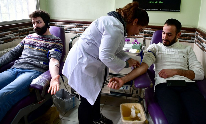 Two men donate blood for quake victims at a blood donation center in Damascus, capital of Syria, on Feb. 8, 2023.(Photo: Xinhua)