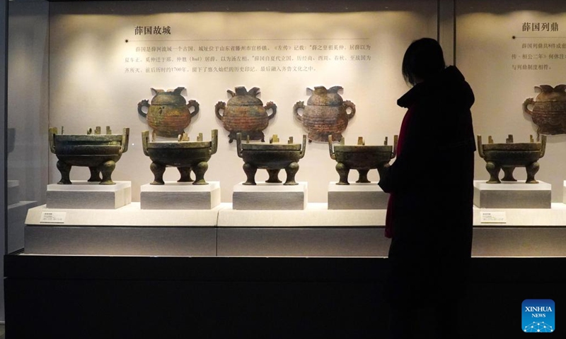 A visitor views bronze exhibits at a Shandong cultural relics exhibition held at Confucius Museum in Qufu, east China's Shandong Province, on Feb. 9, 2023. The exhibition displayed more than 100 cultural relics, mainly including bronze wares, pottery wares and jade wares, from 10 cultural institutions in Shandong Province.(Photo: Xinhua)