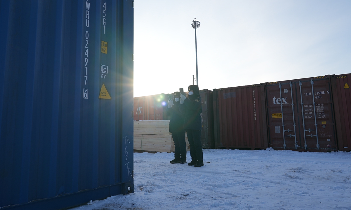 Two workers check goods at a container yard in the Manzhouli port on February 9, 2023. Photo: Pang Yue/GT 