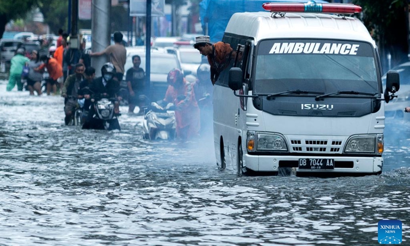An ambulance runs on a flooded road after heavy rain in Makassar, South Sulawesi, Indonesia, Feb. 13, 2023.(Photo: Xinhua)
