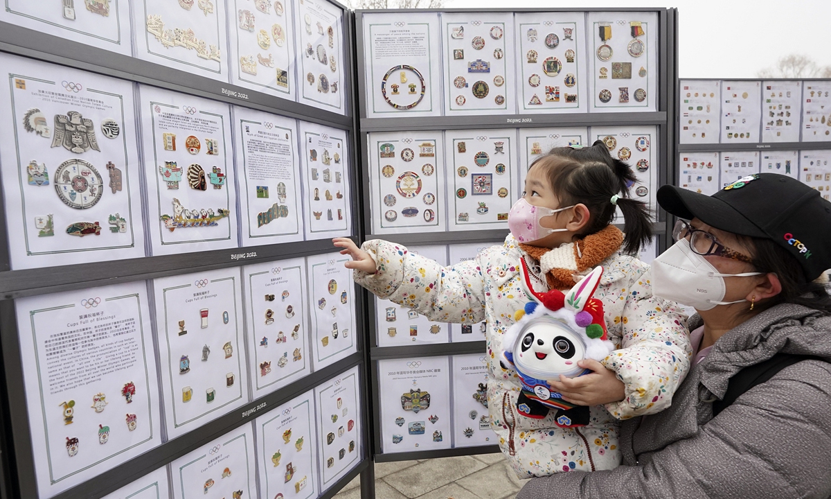 Residents view a badge exhibition at an Olympic culture bazaar as it opens in Beijing's Olympic Forest Park on February 11, 2023 to celebrate the first anniversary of the Beijing 2022 Olympic Winter Games.Photo: VCG