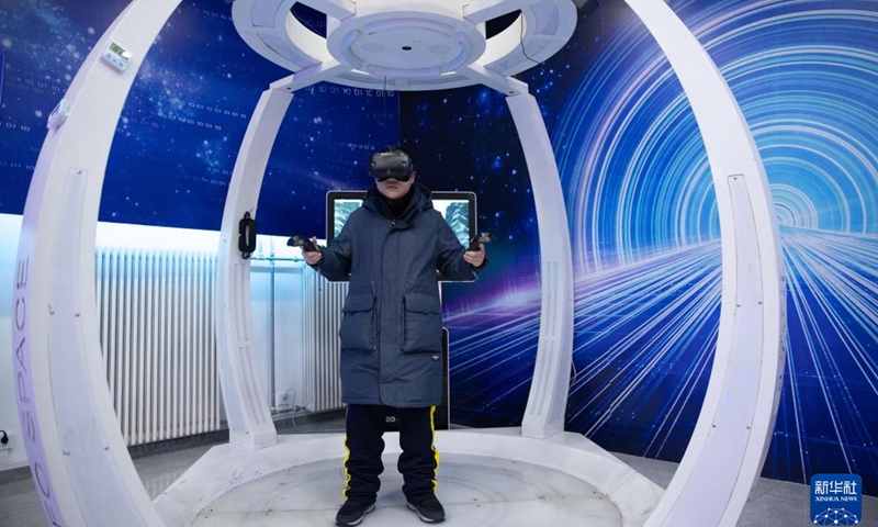 A visitor tries VR devices to experience virtual skiing at an ice and snow metaverse experience center in Harbin, northeast China's Heilongjiang Province, Feb. 12, 2023. Recently, the ice and snow metaverse experience center at the Harbin Ice and Snow World in Harbin has drawn much attention. It enables visitors to enjoy the ice and snow scenery and activities regardless of the seasons.(Photo: Xinhua)