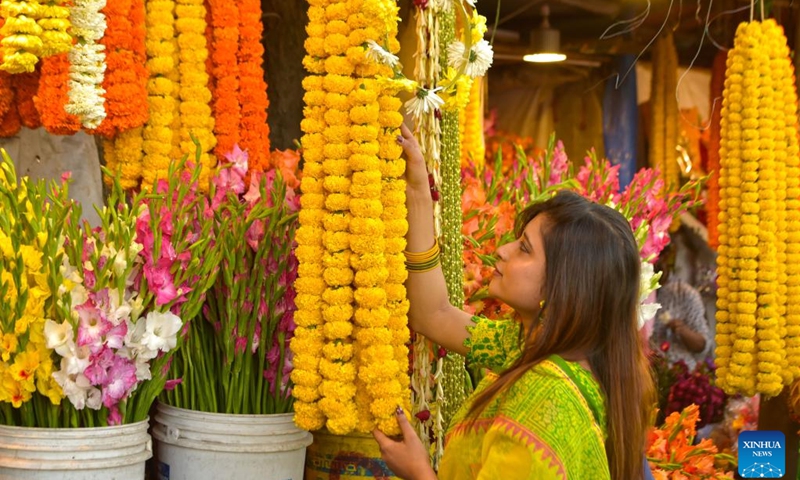 A young woman selects flowers to celebrate the Pohela Falgun in Dhaka, Bangladesh, Feb. 14, 2023. Local dwellers thronged the Bangladeshi capital to celebrate Pohela Falgun, the first day of spring and of the Bengali month Falgun, along with Valentine's Day.(Photo: Xinhua)
