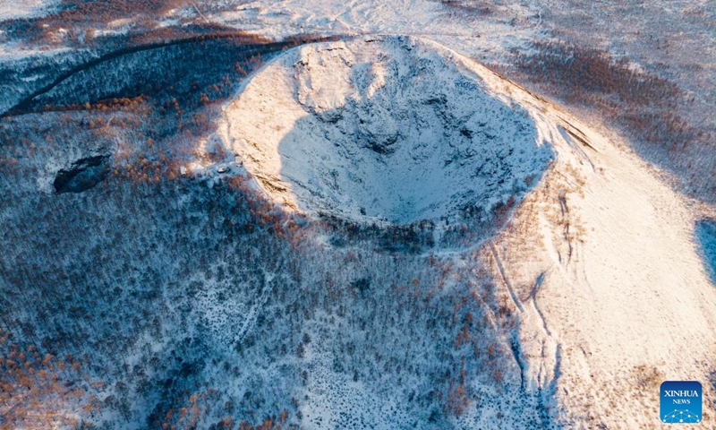This aerial photo taken on Feb. 12, 2023 shows the snow-covered volcanic crater of Laohei Mountain at the Wudalianchi UNESCO Global Geopark in Heihe, northeast China's Heilongjiang Province. The Wudalianchi UNESCO Global Geopark features 14 volcanoes and five major volcanic barrier lakes. The geopark boasts a complete set of volcanic landforms, making it a natural volcano museum.(Photo: Xinhua)