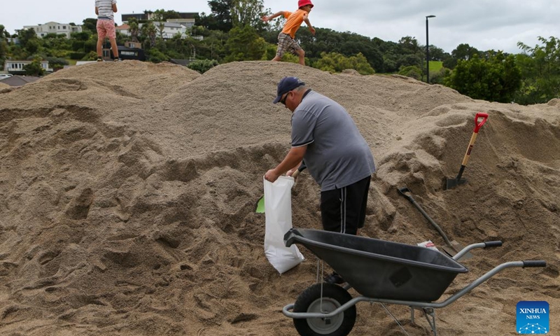 A resident fills a sandbag at a temporary storage site of sand in Auckland, New Zealand, Feb. 11, 2023. New Zealand's largest city Auckland set up temporary storage sites of sand and provided sandbags for residents to get prepared for new severe weather event. The last round of record rainfall has caused massive flooding to houses and properties since Jan. 27.(Photo: Xinhua)