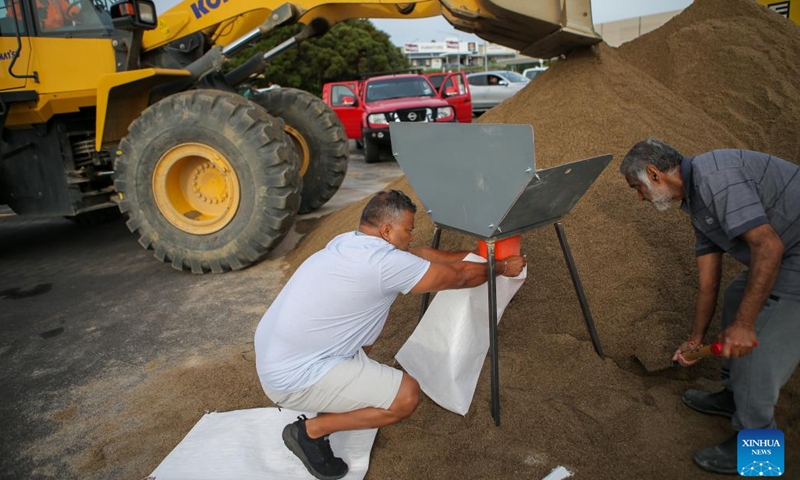 Residents fill a sandbag at a temporary storage site of sand in Auckland, New Zealand, Feb. 11, 2023. New Zealand's largest city Auckland set up temporary storage sites of sand and provided sandbags for residents to get prepared for new severe weather event. The last round of record rainfall has caused massive flooding to houses and properties since Jan. 27.(Photo: Xinhua)