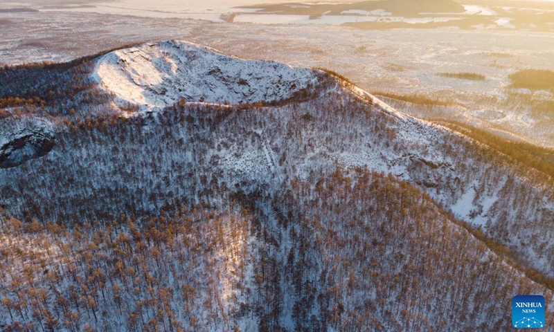 This aerial photo taken on Feb. 12, 2023 shows the snow-covered volcanic crater of Laohei Mountain at the Wudalianchi UNESCO Global Geopark in Heihe, northeast China's Heilongjiang Province. The Wudalianchi UNESCO Global Geopark features 14 volcanoes and five major volcanic barrier lakes. The geopark boasts a complete set of volcanic landforms, making it a natural volcano museum.(Photo: Xinhua)