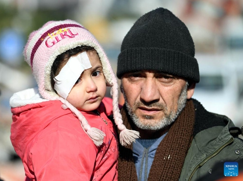 A man holding an injured girl walks on a street in Antakya, Hatay province, Türkiye, on Feb. 11, 2023. The death toll from Monday's devastating earthquakes climbed to 22,327 in Türkiye, while another 80,278 injuries were reported in the country, Turkish Health Minister Fahrettin Koca announced on Saturday night.(Photo: Xinhua)