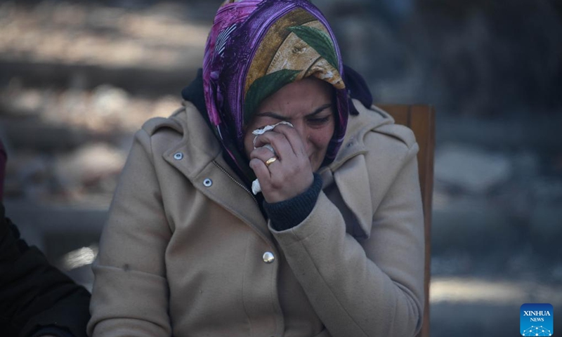 A woman weeps beside earthquake debris in Antakya, Hatay province, Türkiye, on Feb. 11, 2023. The death toll from Monday's devastating earthquakes climbed to 22,327 in Türkiye, while another 80,278 injuries were reported in the country, Turkish Health Minister Fahrettin Koca announced on Saturday night.(Photo: Xinhua)