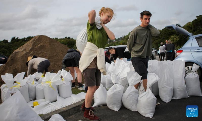 Residents carry sandbags at a temporary storage site of sand in Auckland, New Zealand, Feb. 11, 2023. New Zealand's largest city Auckland set up temporary storage sites of sand and provided sandbags for residents to get prepared for new severe weather event. The last round of record rainfall has caused massive flooding to houses and properties since Jan. 27.(Photo: Xinhua)