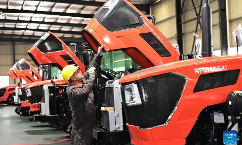 A staff member installs engine hood sealing belts at an electric machinery company in Chenzhou, central China's Hunan Province, Feb. 13, 2023.(Photo: Xinhua)