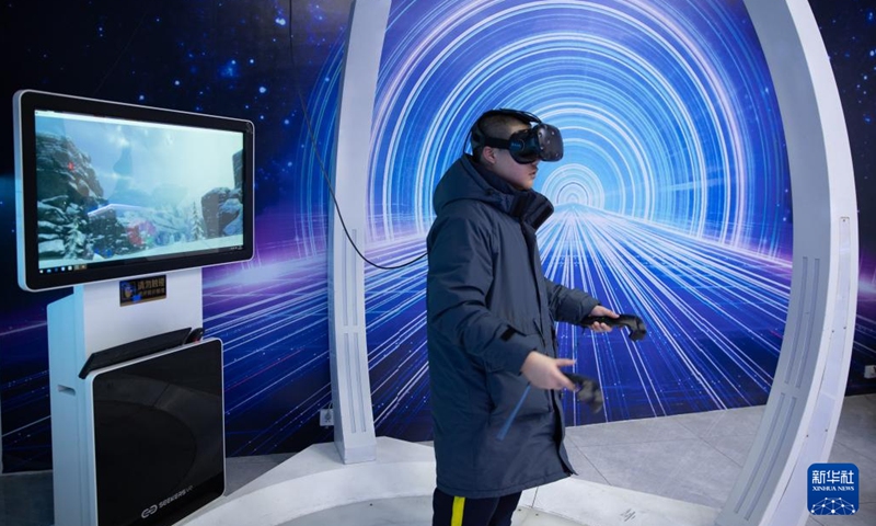 A visitor tries VR devices to experience virtual skiing at an ice and snow metaverse experience center in Harbin, northeast China's Heilongjiang Province, Feb. 12, 2023. Recently, the ice and snow metaverse experience center at the Harbin Ice and Snow World in Harbin has drawn much attention. It enables visitors to enjoy the ice and snow scenery and activities regardless of the seasons.(Photo: Xinhua)