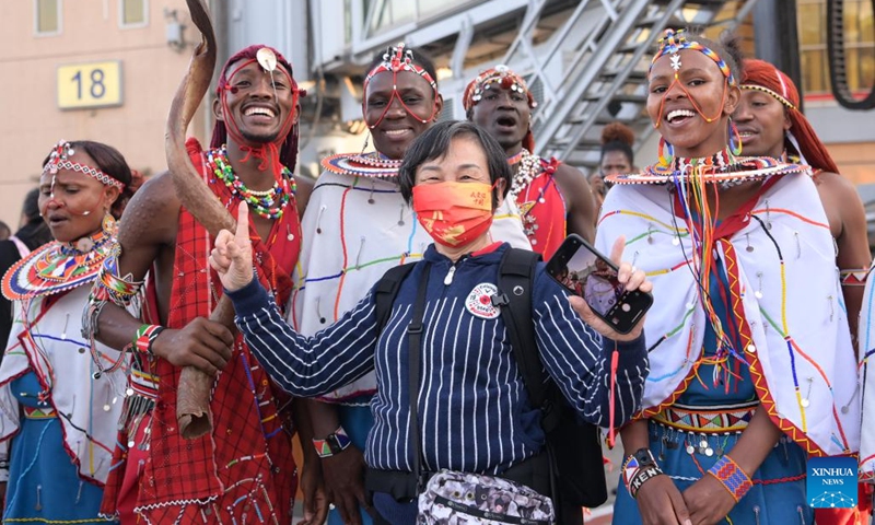 A Chinese tourist poses for a photo with Maasai performers at Jomo Kenyatta International Airport in Nairobi, Kenya, Feb. 11, 2023. A flight carrying 40 Chinese group tourists arrived at Jomo Kenyatta International Airport in Nairobi on Saturday. This is the first outbound tour group from China to Kenya since China resumed outbound group travel to 20 countries. (Photo: Xinhua)