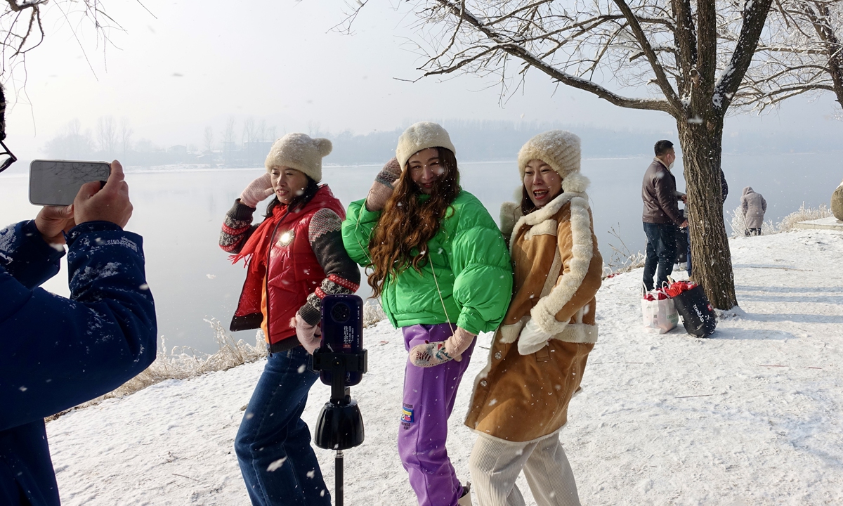 Tourists take photos under rime trees near the Songhua River in Jilin city on February 6, 2023.