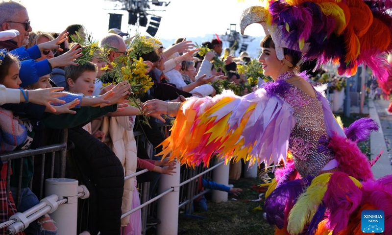 An actress distributes flowers to audiences during the Battle of the Flowers parade of the Nice Carnival in Nice, France, Feb. 15, 2023(Photo: Xinhua)
