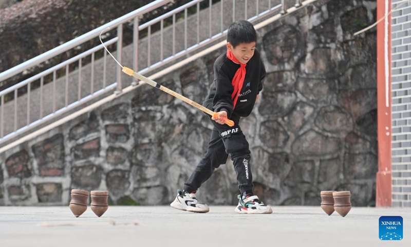 A student plays spinning tops during a PE class at Xiayi Ethnic School in Mengshan County of Wuzhou City, south China's Guangxi Zhuang Autonomous Region, Feb. 22, 2023.(Photo: Xinhua)
