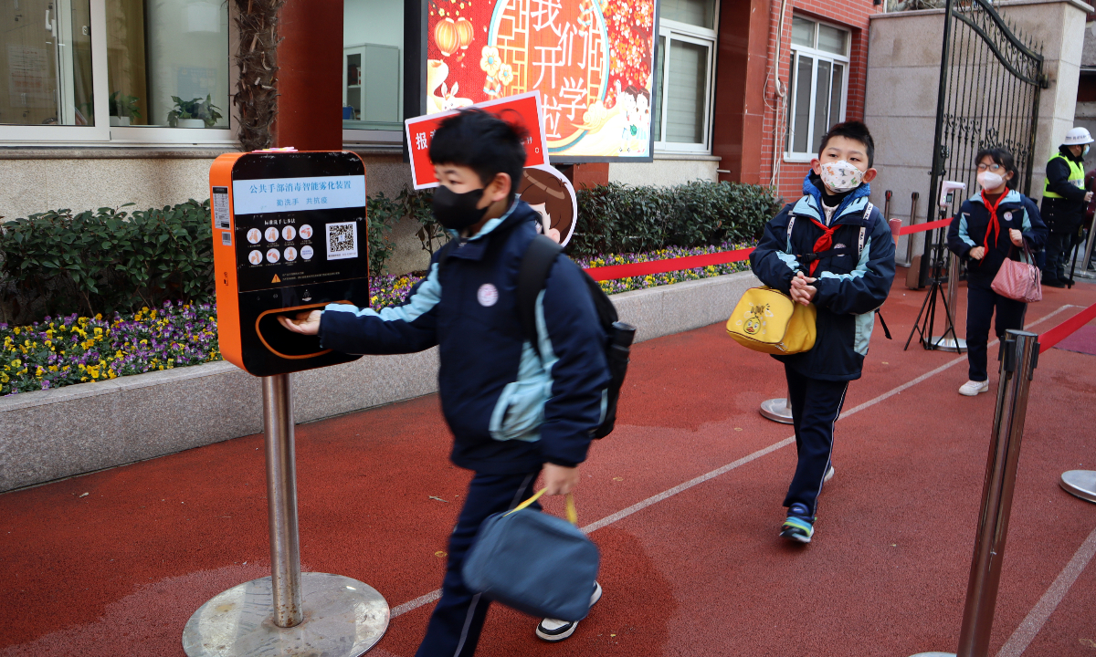 Students sanitize their hands before entering a primary school in Shanghai on February 15, 2023. Photo: IC