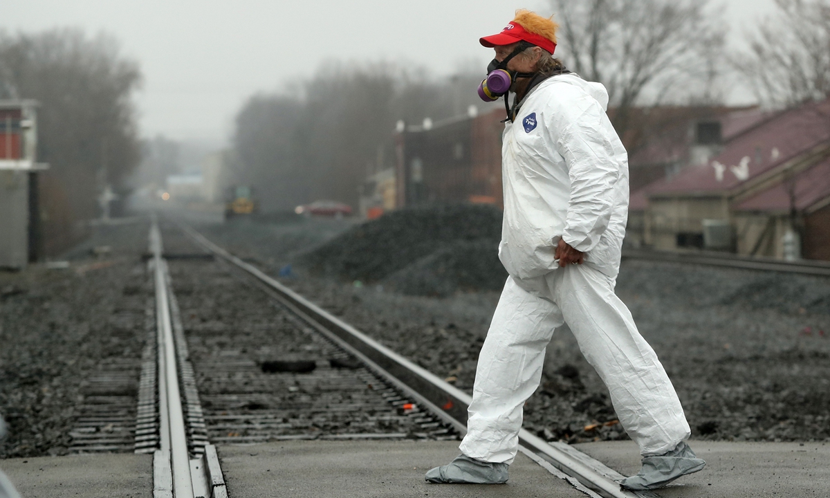  A Donald Trump supporter wears a hazmat suit and respirator as he crosses the railroad tracks prior to Trump's arrival to speak in the village of East Palestine, Ohio on February 22, 2023. A Norfolk Southern train derailed in the village spilling hazardous chemicals on February 3. Photo: VCG