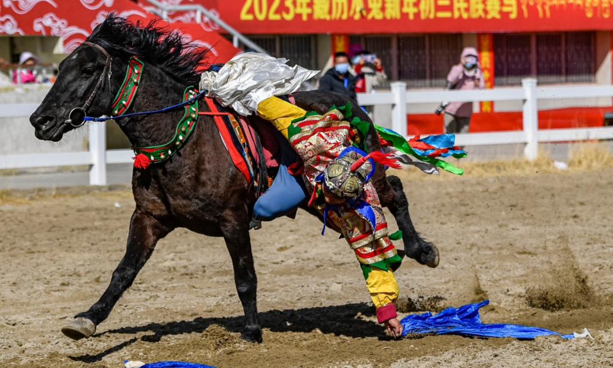 A rider picks up hada during an equestrian show in Lhasa, southwest China's Tibet Autonomous Region, Feb 23, 2023. An annual equestrian show was held here on Thursday to celebrate the Tibetan New Year. Photo:Xinhua