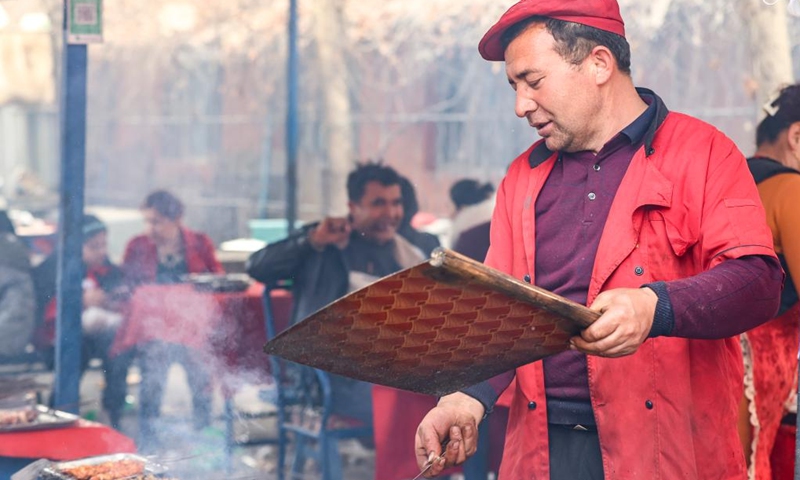 A vendor prepares barbecue at a weekly bazaar in Tokkuzak Township of Shufu County, northwest China's Xinjiang Uygur Autonomous Region, Feb. 26, 2023.(Photo: Xinhua)