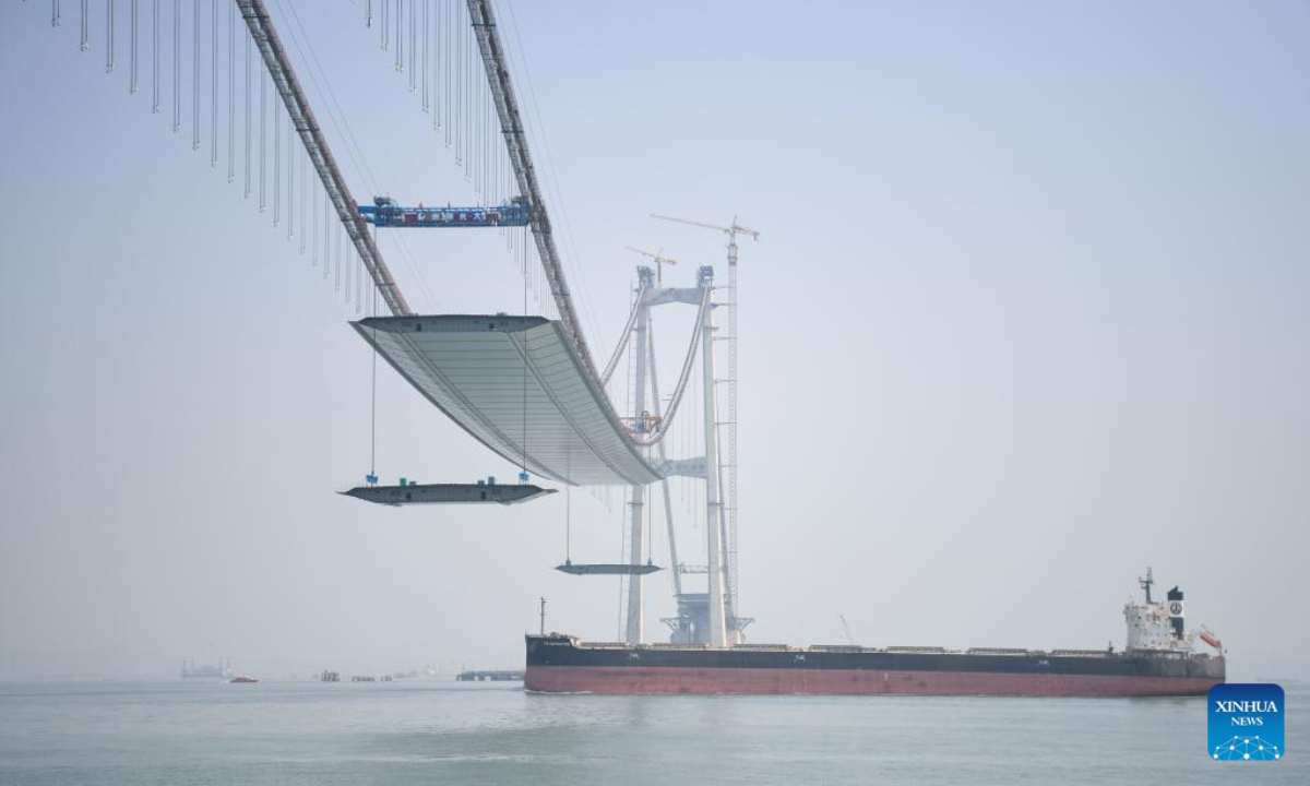 A cargo ship sails beneath the Lingdingyang bridge under construction in south China's Guangdong Province, Feb 22, 2023. The bridge is a key part of the Shenzhen-Zhongshan highway. Photo:Xinhua
