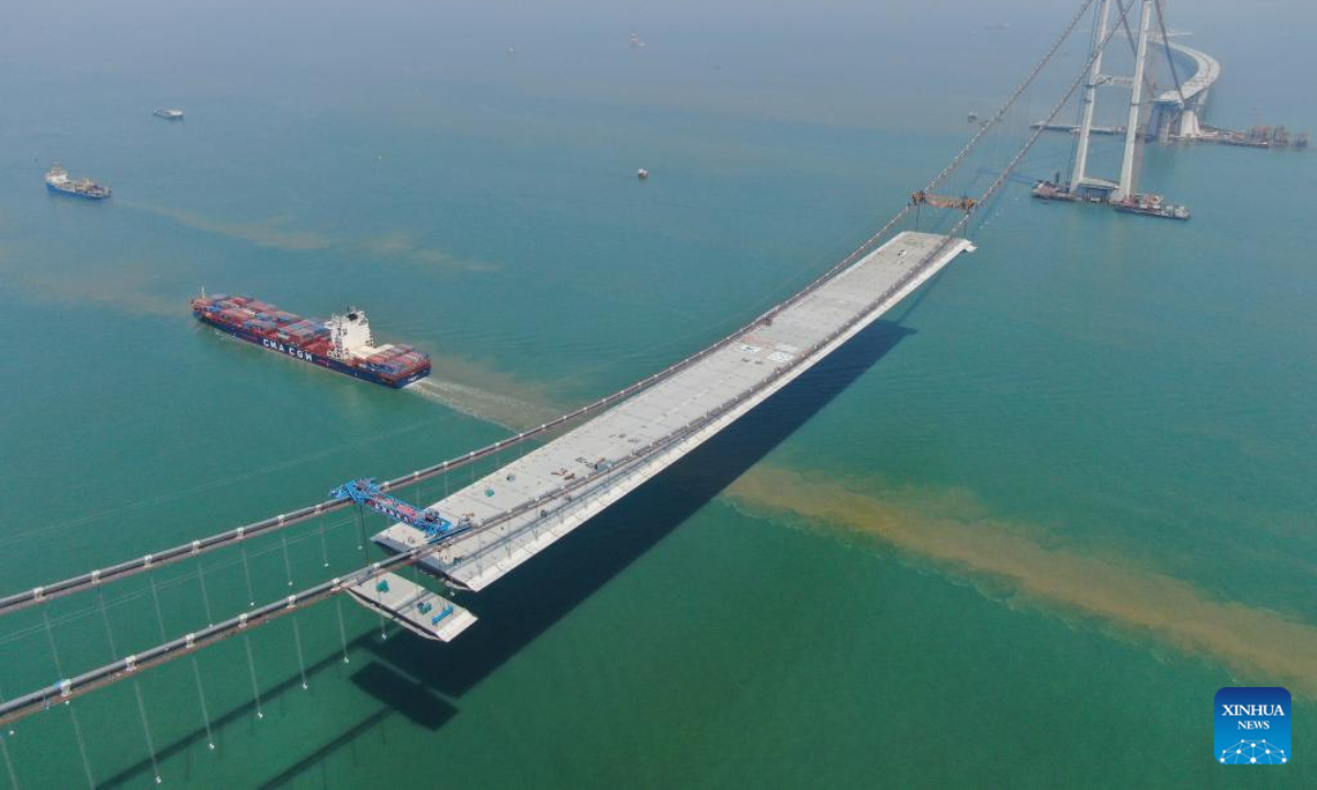 This aerial photo taken on Feb 22, 2023 shows a cargo ship sailing beneath the Lingdingyang bridge under construction in south China's Guangdong Province. The bridge is a key part of the Shenzhen-Zhongshan highway. Photo:Xinhua