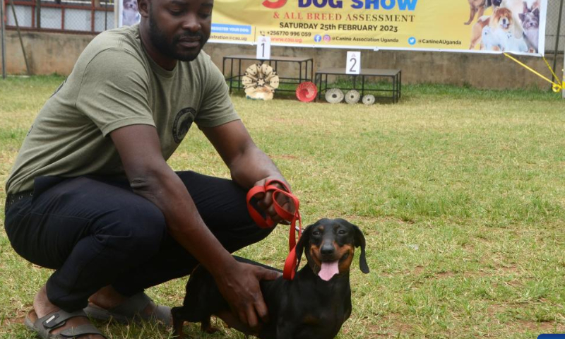 A man poses for photos with his dog during a national dog show held in Kampala, Uganda, Feb. 25, 2023. (Photo by Nicholas Kajoba/Xinhua)