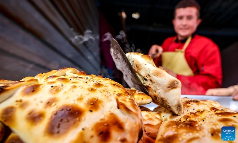 A vendor makes traditional food at a weekly bazaar in Tokkuzak Township of Shufu County, northwest China's Xinjiang Uygur Autonomous Region, Feb. 26, 2023.(Photo: Xinhua)