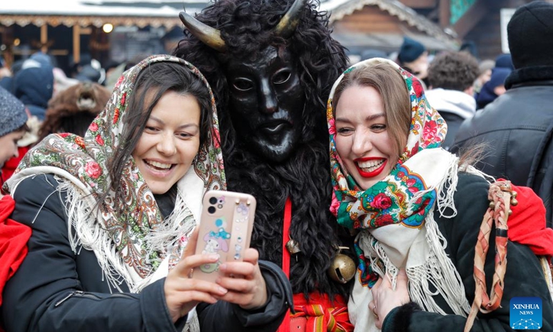 People pose for photos with an actor during Maslenitsa celebrations in Moscow, Russia, Feb. 26, 2023. Maslenitsa is a traditional holiday to celebrate the beginning of spring.(Photo: Xinhua)