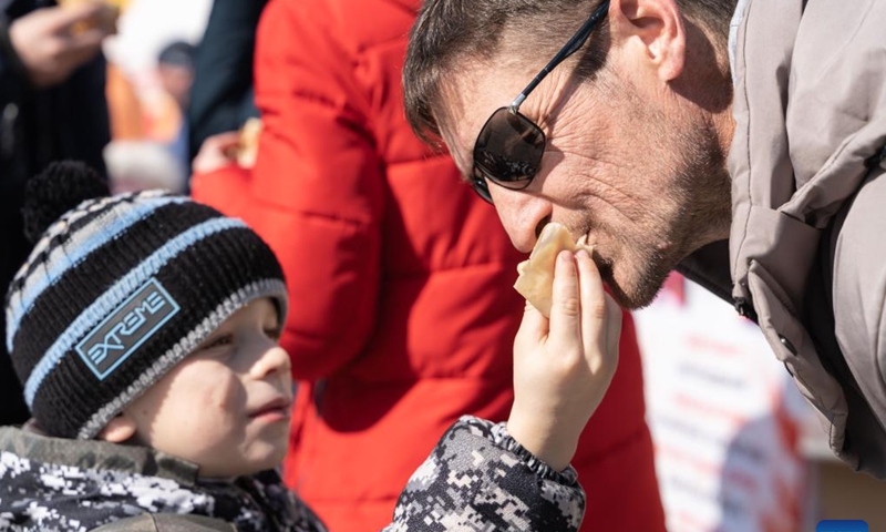 A boy shares a pancake with his father during the celebration of Maslenitsa in Vladivostok, Russia, Feb. 26, 2023.

Maslenitsa is a traditional holiday to celebrate the beginning of spring. (Photo by Guo Feizhou/Xinhua)
