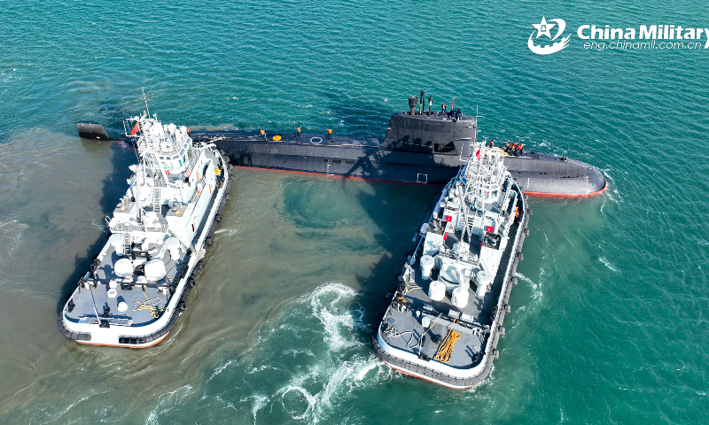 Two towboats attached to a naval submarine flotilla under the PLA Northern Theater Command tow a submarine to bear off a port during a day-and-night training exercise in late February, 2023. (eng.chinamil.com.cn/Photo by Shi Jialong)