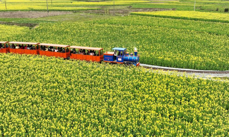 People take a sightseeing train at a scenic spot in Wuyuan County of east China's Jiangxi Province, March 3, 2023. Spring scenery in Wuyuan attracts lots of visitors with the rising of temperature. (Xinhua/Wan Xiang)