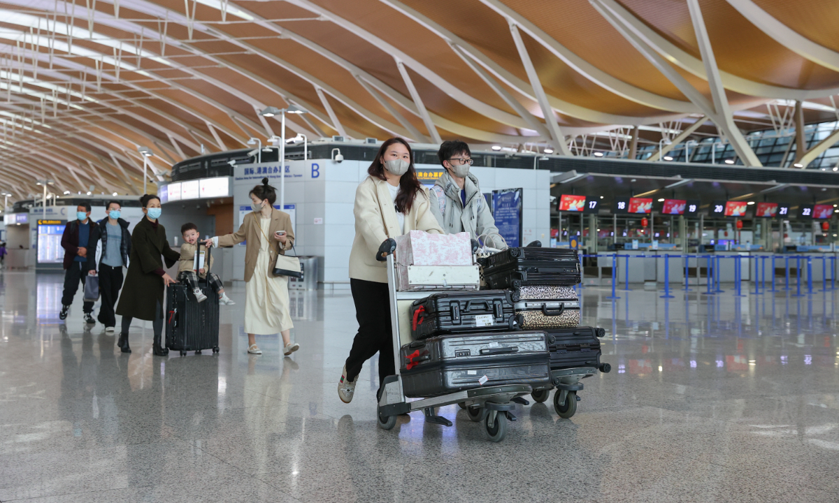 Travelers carry their luggage before boarding an international flight from Shanghai Pudong International Airport on February 6, 2023. Photo: IC