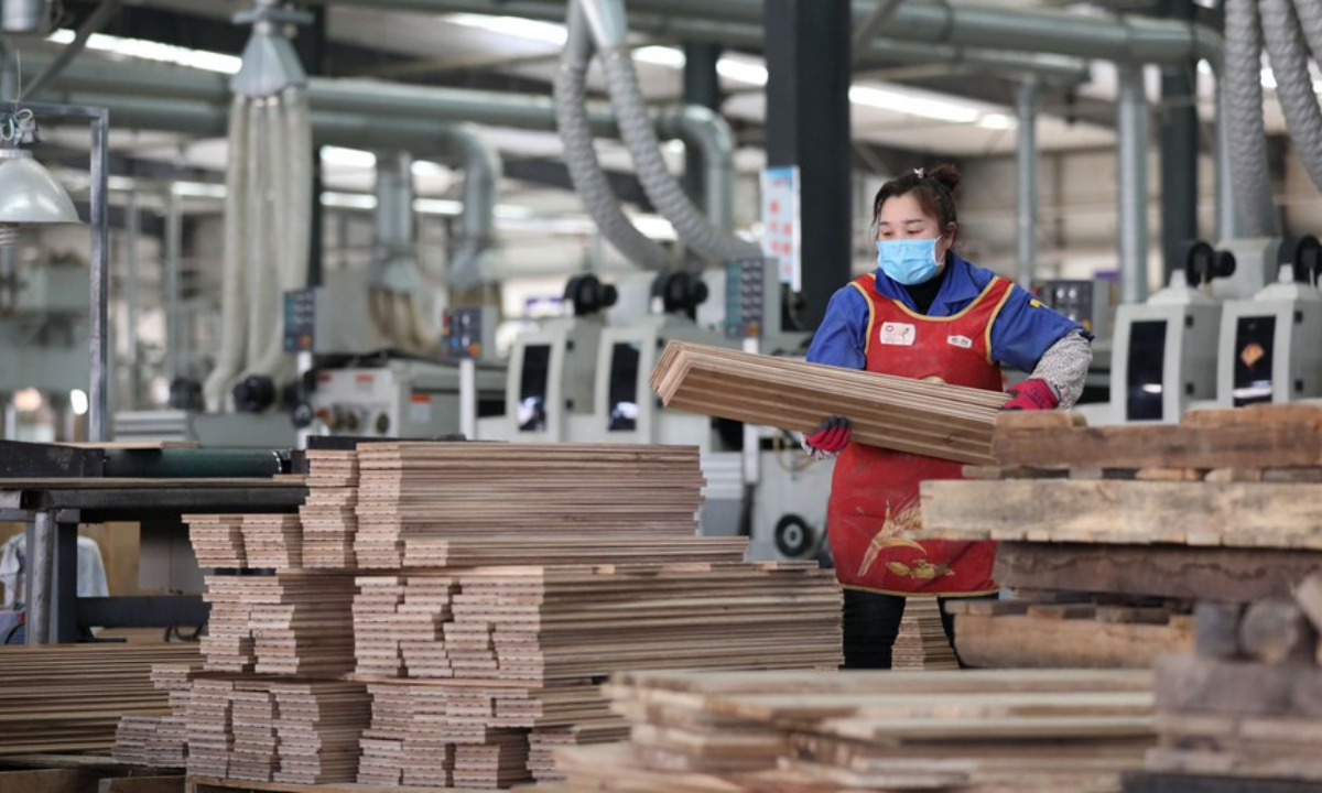 A worker arranges newly-produced floorboards at a factory in Benxi, northeast China's Liaoning Province, March 17, 2020. Photo:Xinhua