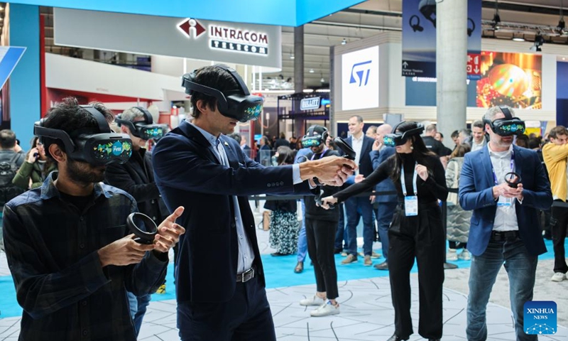Visitors try out VR helmets at the 2023 Mobile World Congress (MWC) in Bacelona, Spain, Feb. 28, 2023. From foldable phones to rollable screens, the latest technological innovations in the mobile communication industry are on display at the 2023 Mobile World Congress (MWC), which runs here from Feb. 27 to March 2.(Photo: Xinhua)