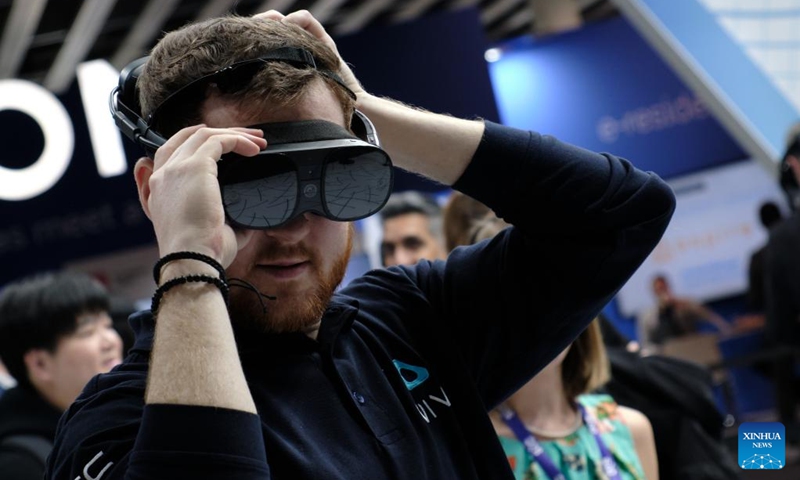 A man tries out a VR helmet at the 2023 Mobile World Congress (MWC) in Bacelona, Spain, Feb. 28, 2023. From foldable phones to rollable screens, the latest technological innovations in the mobile communication industry are on display at the 2023 Mobile World Congress (MWC), which runs here from Feb. 27 to March 2.(Photo: Xinhua)