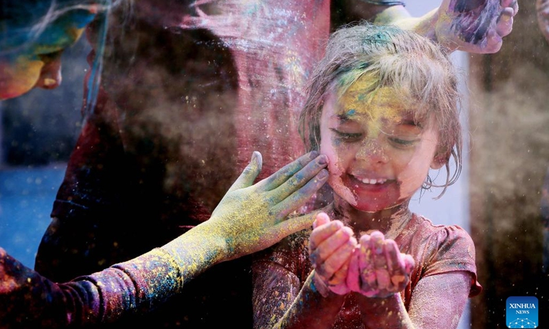 A kid plays with colored powder during the celebration of Holi Festival in Bengaluru, India, March 7, 2023.(Photo: Xinhua)