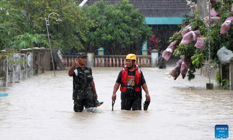 Miembros de un equipo de búsqueda y rescate caminan a través de las aguas de la inundación después de fuertes lluvias y el desbordamiento del río Bengawan Solo en Sragen, Java Central, Indonesia, el 2 de marzo de 2023. (Foto: Xinhua)