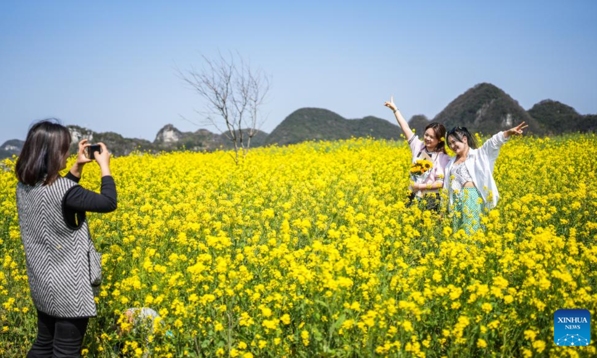 Tourists take photos in a cole flower field in Wayao Village of Mugang Town, Liuzhi Special District, Liupanshui, southwest China's Guizhou Province, March 9, 2023. Photo:Xinhua