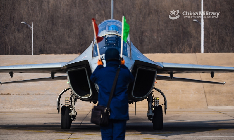A ground crew member assigned to a regiment of the Naval Aviation University guides a two-seat JL-10 jet trainer to the take-off line during a flight training exercise held in early February, 2023. (eng.chinamil.com.cn/Photo by Xu Yinglong)