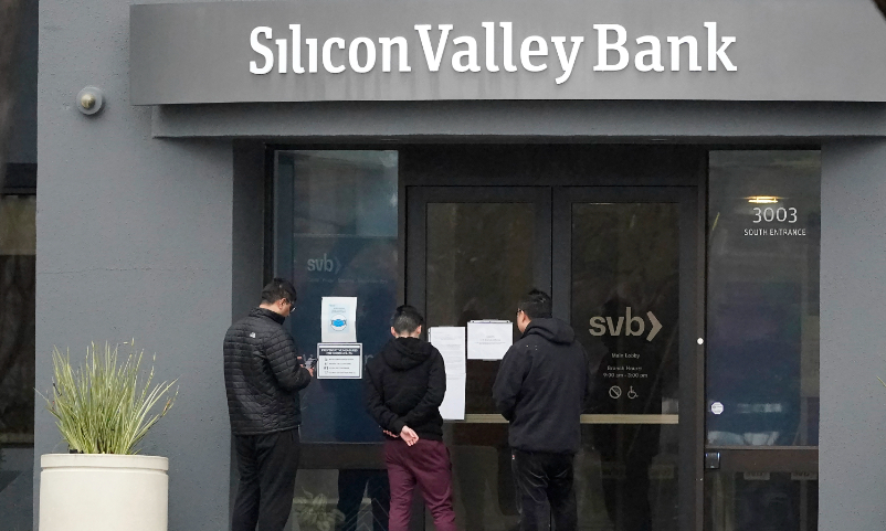 People look at signs posted outside of an entrance to Silicon Valley Bank in Santa Clara, California, on March 10, 2023. Photo: VCG   