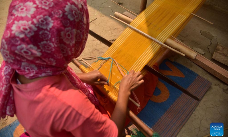A woman weaves a Jamborong (traditional bag) in Karbi Anglong district of India's northeastern state of Assam, March 12, 2023. (Str/Xinhua)