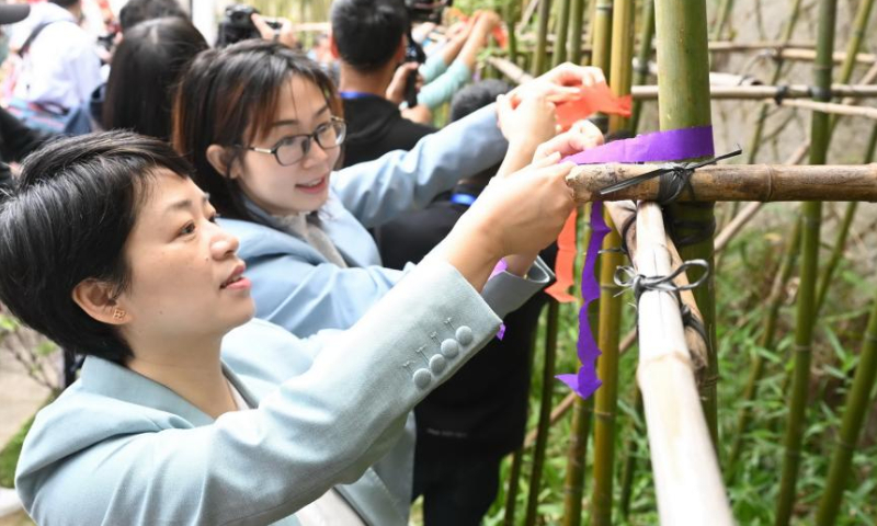 People tie colored ribbons to celebrate Hua Zhao Jie, meaning Flower Festival, at a park in Fuzhou, southeast China's Fujian Province, March 11, 2023. (Xinhua/Lin Shanchuan)